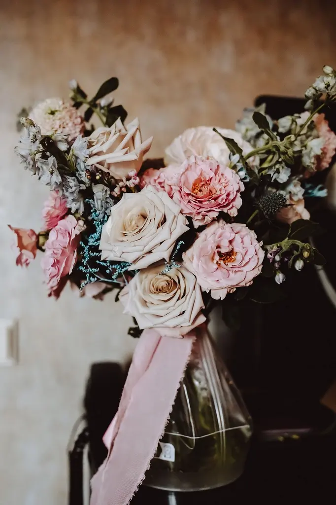 Wedding Planner Warszawa, Bukiet różowych i niebieskich kwiatów na stole, idealny do dekoracji ślubnych